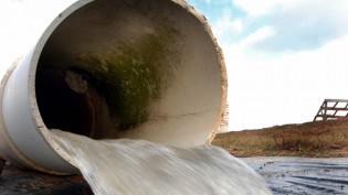 Simulated storm water run-off pours into a retention pond at the erosion control simulator off Lake Wheeler Road. Photo by NC State Communications