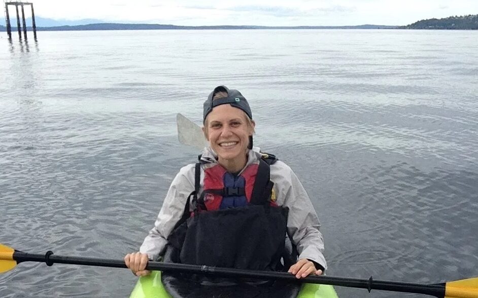 Annie Grant poses for a photo while paddling in a sea kayak in Puget Sound, WA.