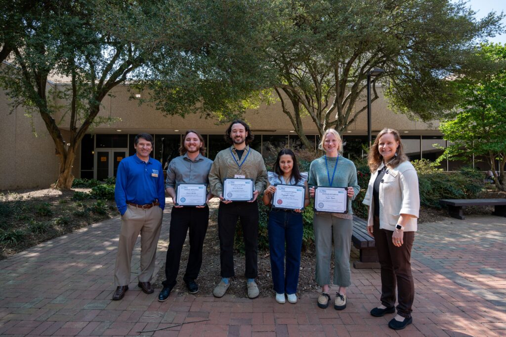 Six people posing with award certificates